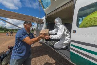 “Wings of Emergency-Projekt” in Brasilien 2020 - ein Greenpeace Mitarbeiter nimmt Covid-Hilfsgüter aus einem Flugzeug entgegen