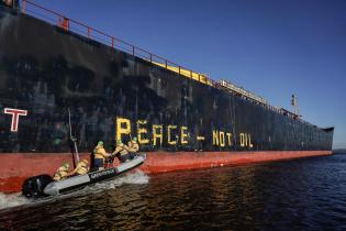 Greenpeace Aktivist:innen sind auf dem Weg, um in zwei Meter hohen Buchstaben "Frieden - nicht Öl" in englischer Sprache auf die Seite des 40.000-Tonnen-Tankers Seasprat zu malen, der verarbeitetes Öl aus dem russischen Ostseehafen Primorsk liefert.
