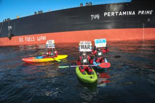 Friedliche Aktion gegen russische Öltransporte in Dänemark: Schwimmer:innen und Aktivist:innen in Kajaks und Ruderbootenprotestieren gegen das Verladen von  russisches Öl.
