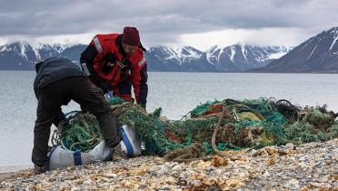 Zwei Greenpeace-Aktivisten mit Fischereimüll am Strand von Spitzbergen