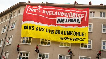 Greenpeace-Aktivisten hängen Banner am Karl-Liebknecht-Haus