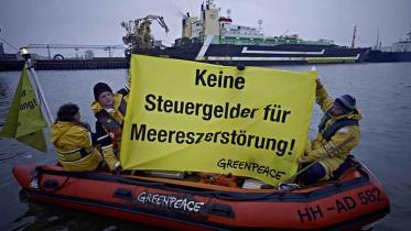 Protest mit einem Banner am Trawler "Jan Maria" gegen Subventionen für Überfischung, Dezember 2011.