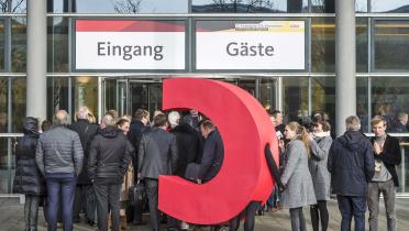 C steht vor dem "Eingang"-Schild vom  CDU Parteitag
