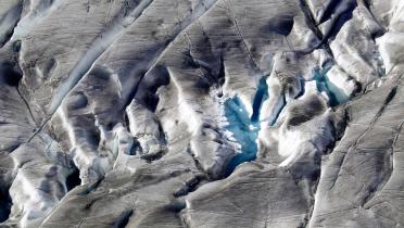 Die Antarktis aus der Vogelperspektive: Mit Eis und Schnee bedeckte Berge, dazwischen kristallklare Seen
