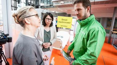 Im Landtag von NRW übergibt ein Greenpeace-Mitarbeiter Vertretern der Landesregierung einen Protestbrief zu den zu hohen Stickoxidwerten.