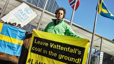 Aktivist mit Banner "Kohle im Boden lassen!" vor der schwedischen Botschaft in Berlin