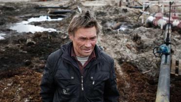 Sergey Kechimov steht inmitten einer ölüberschwemmten Landschaft