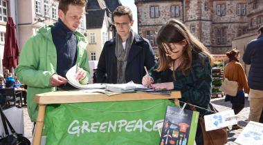 Auf dem Marburger Marktplatz sammeln Greenpeace-Aktivisten Unterschriften gegen TTIP