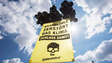 Mit einem Banner mit der Aufschrift "Braunkohle zerstört das Klima. Schluss damit!" protestieren Greenpeace-Aktivisten vor der Tagung des Bundesverband Braunkohle