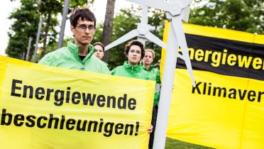 Greenpeace-Aktivisten protestieren gegen das von der Bundesregierung geplante Bremsen der Energiewende; auf ihren Bannern steht "Energiewende beschleunigen".