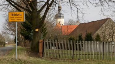 Das Ortseingangsschild des Ortes Pödelwitz in Sachsen. Er soll dem Braunkohle-Tagebau weichen.