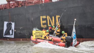 Greenpeace-Aktivisten in Schlauchbooten schreiben "End Coal" an die Bordwand des Frachters "Golden Opportunity".