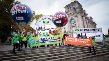 Greenpeace-Aktivisten mit Banner "Illegalize It" in Berlin