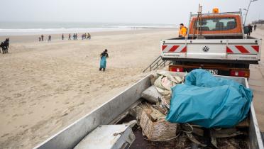 Feuerwehr mit Anhängeer voll Müll am Strand