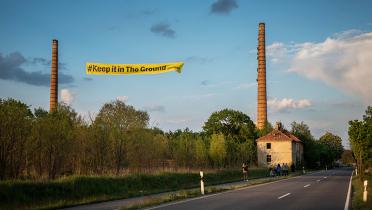 Banner "Keep It In The Ground" zwischen Schornsteinen in Haidemühl