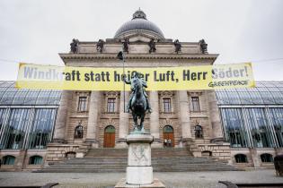 Banner hängt vor Staatskanzlei, darauf steht: "Windkraft statt heißer Luft, Herr Söder!"