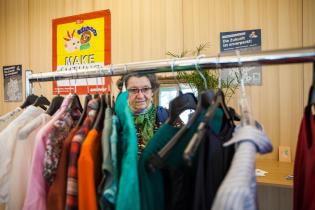 Frau wählt auf Kleidertauschparty in Würzburg Second Hand Kleidung aus