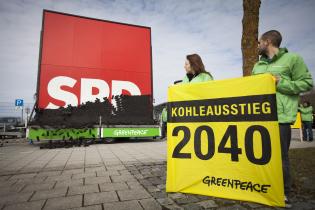 Eingestürzte Mauer von Kohlebriketts vor dem SPD-Logo