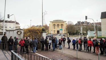 Viele Menschen warten vor der Polizeistation in Thionville darauf, Anzeige erstatten zu können wegen Gefährdung Dritter – u. a. gegen den Atomkonzern EDF. Der Grund: Atomkraftwerke in Frankreich weisen erhebliche Sicherheitsmängel auf.