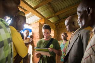 Greenpeace-Mitarbeiter Sylvain Trottier mit Dorfbewohnern in einem unfertigen Haus