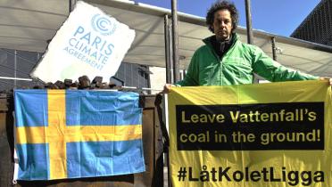 Aktivist mit Banner "Kohle im Boden lassen!" vor der schwedischen Botschaft in Berlin