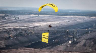 Paraglider von Greenpeace fliegt über den Tagebau Welzow Süd.