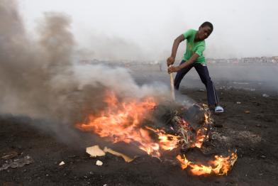 Junge in Ghana verbrennt elektronische Kabel, um den Kunststoff zu schmelzen und die Kupferdrähte zurückzugewinnen. Bei dieser Verbrennung in kleinen Feuern werden giftige Chemikalien in die Umwelt freigesetzt. 