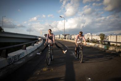Zwei Menschen auf Fahrrädern auf einem Radweg