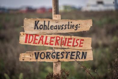 Mit einer roten Linie zwischen Lützerath und dem Braunkohletagebau Garzweiler  protestieren Greenpeace-Aktivist:innen gegen die Zerstörung des Dorfes durch den Kohlekonzern RWE. Auf  einer Feuerlinie steht "1,5°C LIMIT", auf Bannern ist zu lesen "1,5°C bedeutet: Lützerath bleibt".