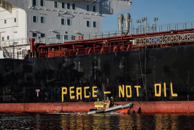 Greenpeace Aktivist:innen im Schlauchboot um "Peace - Not Oil" auf die Seite des 40.000-Tonnen-Tankers Seasprat zu malen, der verarbeitetes Öl aus dem russischen Ostseehafen Primorsk liefert.