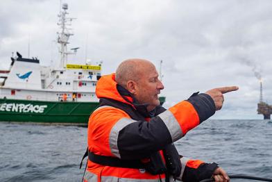 Christian Bussau im Schlauchboot vor der Esperanza. Das Greenpeace-Schiff Esperanza fährt vor der von Shell betriebenen Ölplattform Brent-C (Charlie) im Hintergrund vorbei.