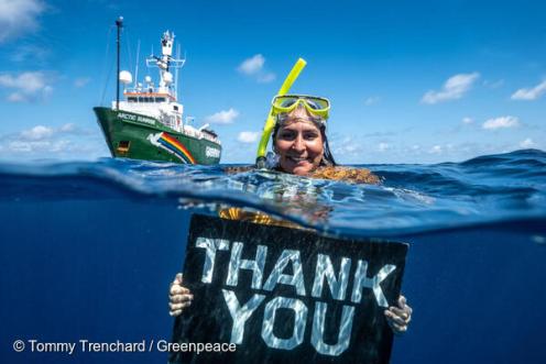 Kampaignerin Juliana Costa im Indischen Ozean mit Danke-Plakat
