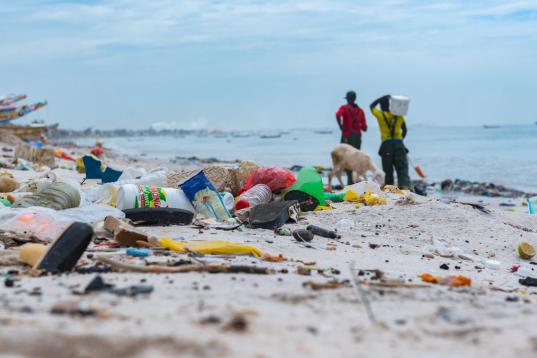 Menschen säubern den Strand im Senegal. Die Strände sind mit Plastikmüll und vom Meer angespülter Verschmutzung übersät.