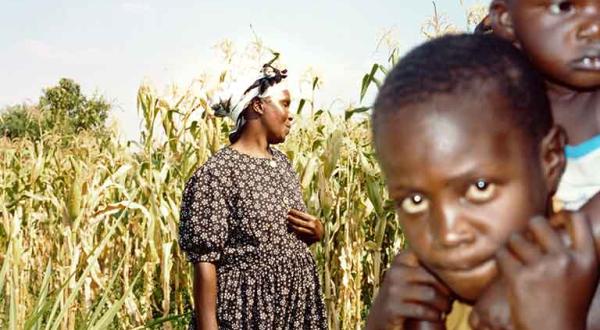 Mutter mit Kindern vor einem Maisfeld in Kenia, Juni 2001.