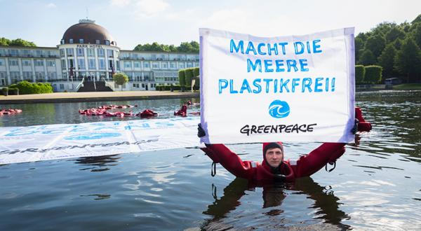 Aktivist mit Banner "Macht die Meere plastikfrei"