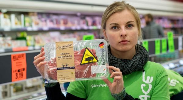 Greenpeace-Aktivistin mit umetikettiertem Billigfleisch von Lidl
