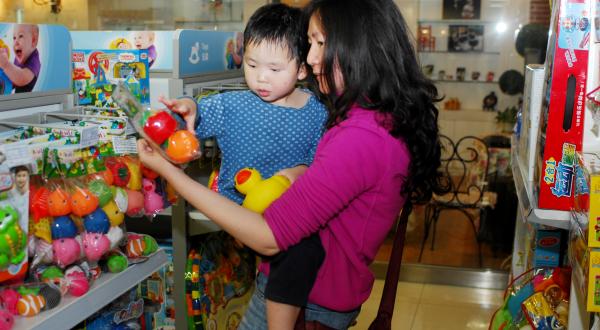 Ein Kind im Spielwaren Geschäft sucht sich ein Plastik Spielzeug aus, August 2011, 