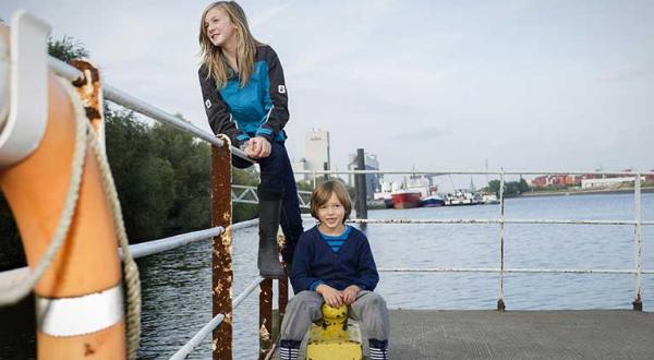 Kinder in Outdoor-Kleidung am Hafen in Hamburg.