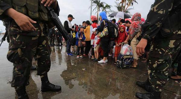 Philippinen, November 2013: Bewohner von Tacloban warten auf einen Platz im Flugzeug nach Manilia. Der Taifun Haiyan hat die Versorgung vor allem mit Trinkwasser lahmgelegt