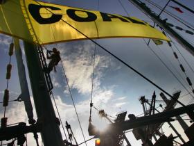 A Greenpeace activist onboard the Greenpeace flagship Rainbow Warrior hangs a giant banner reading "Quit coal" at the vessel's masts to drive home the message that the Philippine government should stop building and expanding harmful coal-fired power plant