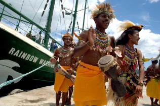 Traditionelle Tänzer aus Kayopulau (Papua) begrüßen die Rainbow Warrior II. Greenpeace ist vor Ort und prangert die Zerstörung der uralten Wälder Indonesiens an. Sie werden schneller zerstört als alle anderen Wälder der Erde, das Holz kaufen die EU, USA, Japan und Chinas (03/2006).)