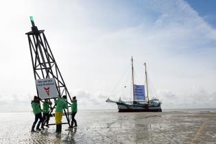 "DEA - keine neuen Ölbohrungen im Wattenmeer!" Greenpeace-Aktivist:innen protestieren mit der Beluga II gegen die Pläne des russischen Ölkonzerns Dea, im Nationalpark Wattenmeer nach Öl zu bohren. Ein nachgebauter Bohrturm soll die Bedrohung des Schutzgebietes verdeutlichen.