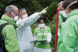 Fukushima-Bürger:innen und Greenpeace-Strahlenmessteam in einem kontaminierten Haus in der Sperrzone Namie, Präfektur Fukushima.