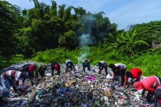 Im Dorf Sumengko in der Nähe von Gresik, Indonesien: Dorfbewohner:innen heben weggeworfenes importiertes Plastik auf, das dort von einem nahe gelegenen Papierrecyclingunternehmen entsorgt wurde, dessen importiertes Papier mit Plastik kontaminiert war. 