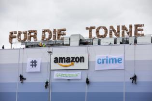 Greenpeace-Aktivist:innen demonstrieren am Amazon Prime Day im Logistikzentrum Winsen an der Luhe gegen die Vernichtung von Neuware. Die Aktivist:innen bringen einen 27 Meter langen Schriftzug aus Versandkartons an, der die Worte "für die Mülltonne" bildet. Das Logo des Online-Versandhändlers veränderten sie mit Bannern zum Hashtag "#amazoncrime".