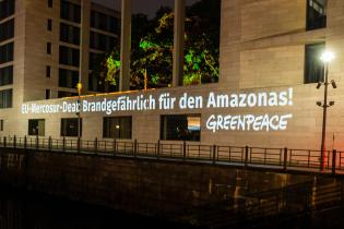 Greenpeace-Aktivist:innen projizieren in den frühen Morgenstunden "Brandgefahr für den Amazonas: Stoppt das EU-Mercosur-Abkommen" an die Fassade des Auswärtigen Amtes.