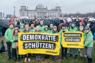 Greenpeace-Aktive mit Bannern "Demokratie schützen" auf der Demonstration für Demokratie vor dem Reichstag in Berlin