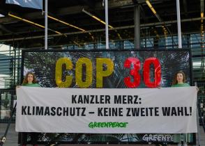 Sarah Zitterbarth and Anna Sara Wolf hold up Banner in Bonn