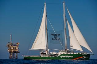 Kampagne gegen Ölforderung in der Nordsee 2020: Die Rainbow Warrior III passiert die Gasplattform A6-A vorbei. Sie trägt dabei ein Banner mit der Aufschrift mit einem Banner mit der Aufschrift "PROTECT THE OCEANS" (Schützt die Meere). Die Plattform liegt im deutschen Teil der Nordsee im Gasfeld A6/B4.