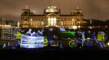 Aktivist:innen demonstrieren mit einem digitalen Hologramm vor dem Bundestag in Berlin für eine Reform der Gemeinsamen Agrarpolitik (GAP).